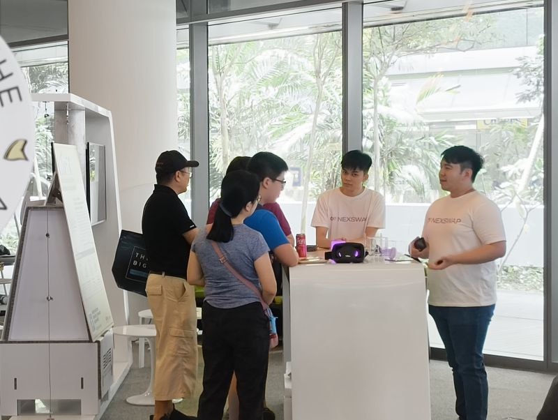 Visitors trying NexSwap badges at the booth during SUTD Open House
